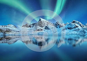 Aurora Borealis, Lofoten islands, Norway. Northen lights, mountains and reflection on the water. Winter landscape during polar lig