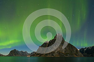 Aurora Borealis on the Lofoten Islands, Reine Norway. Green northern lights above mountains. Night sky with polar sky