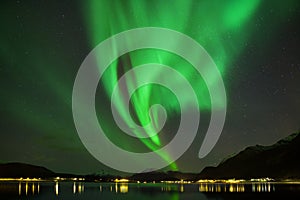 Aurora Borealis on the Lofoten Islands, Reine Norway. Green northern lights above mountains. Night sky with polar sky