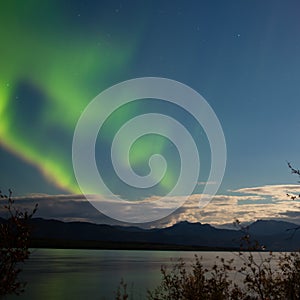 Aurora borealis moon-lit clouds over Lake Laberge