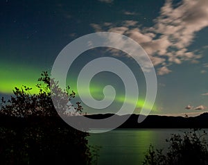 Aurora borealis moon-lit clouds over Lake Laberge