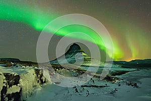 Aurora Borealis the Northern Light at Kirkjufell Iceland. scenic view of waterfall Kirkjufellsfoss aurora polaris in background.