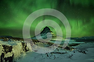 Aurora Borealis the Northern Light at Kirkjufell Iceland. scenic view of waterfall Kirkjufellsfoss aurora polaris in background.