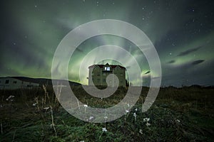 Aurora Borealis Northern Lights above a haunted house landscape