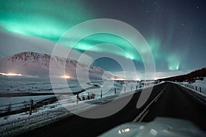 Aurora borealis, northern lights over the road, dancing queen on the clear sky during winter, Iceland