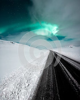 Aurora borealis, northern lights over the road, dancing queen on the clear sky during winter, Iceland