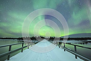 Aurora borealis over a bridge in winter, Finnish Lapland