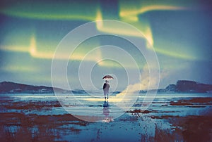 Aurora borealis over man with umbrella