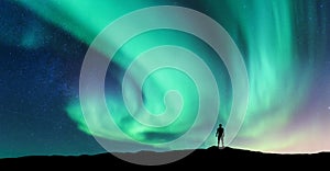 Aurora borealis and silhouette of standing man