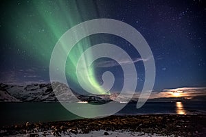 Aurora Borealis in Tromso, Norway in front of Norwegian fjord at winter