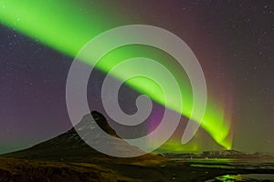 Aurora dancing over Kirkjufell mountain with fully of start night view