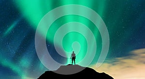 Aurora and silhouette of alone standing man on the hill