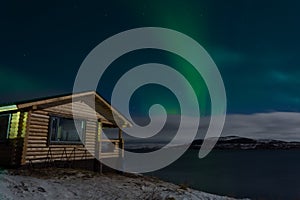 Aurora and a small wooden house
