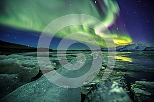 Auroral over the glacier lagoon Jokulsarlon in Iceland.