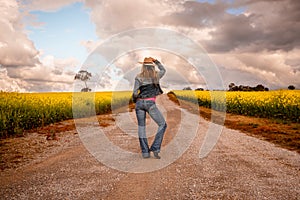 Aussie country girl standing on dirt road in farm fields