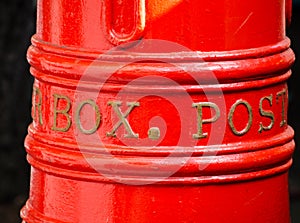 Australia Classic red mail post box in close up, isolated on black background.