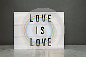 Light box with `love is love` and rainbow photo