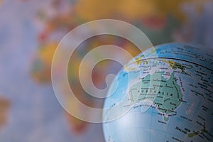 Australiamap on a globe with earth map in the background.