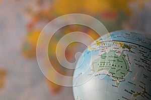 Australiamap on a globe with earth map in the background.