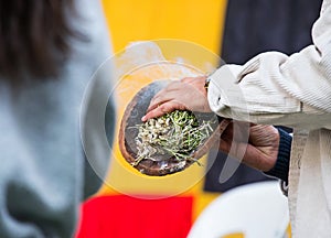 Australian Aboriginal Ceremony, man hand with green branches and flame, start a fire for a ritual rite, South Australia photo