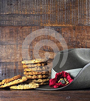 Australian army slouch hat and traditional Anzac biscuits on dark recycled wood photo