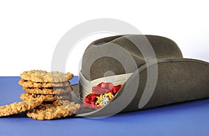 Australian army slouch hat and traditional Anzac biscuits on white and blue background photo