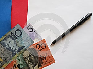 australian banknotes, black pen and white sheet of paper