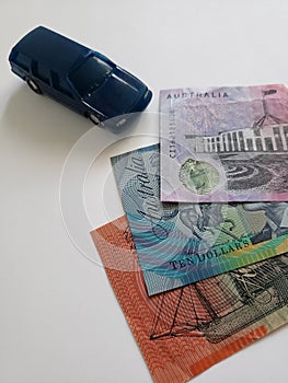 australian banknotes and figure of a car in dark blue