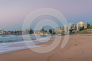 Australian beach on sunrise with waterfront property on the background