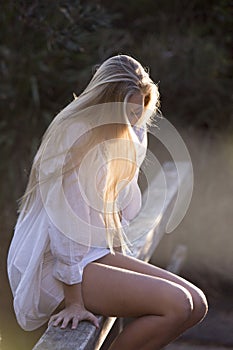 Australian Beauty with Long Blond Hair Looks Down with Sun Streaming Through Hair