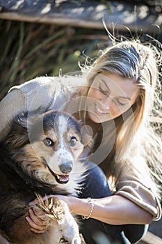 Australian Beauty with Long Blond Hair sits with her collie dog.