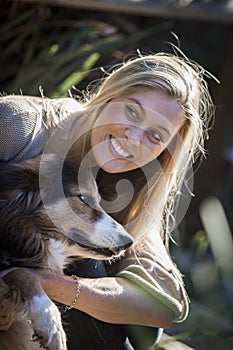 Australian Beauty with Long Blond Hair sits with her collie dog.