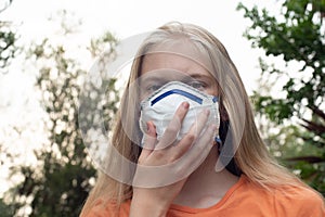 Australian bushfire: blond girl wearing P2 N95 protection respiratory mask to reduce amount of breathing PM2.5 particles from photo