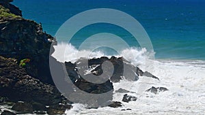 Australian coast, view from a cliff to the blue ocean with a rocky shore on a sunny day. Sea landscape, waves crashing on rocks