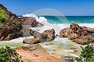 Australian coast with volcanic rocks at the shore, view from the cliff on the seaside landscape.