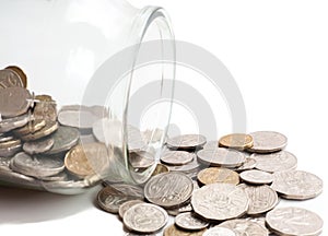 Australian coins spilling out of a glass jar