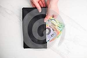 Australian dollar banknotes in a black wallet on the white background