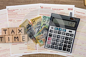 Australian dollar banknotes with wooden cubes at tax form