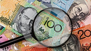 australian dollar and magnifying glass. money concept