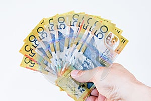 Australian Fifty dollar notes spread in hand.