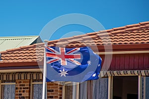 Australian flag blowing in the wind on the resedential building. Australia day celebrations
