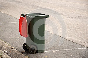 Australian garbage wheelie bin with red lid photo