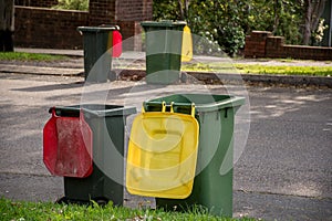 Australian garbage wheelie bins with colourful lids for general and recycling household waste lined up on the street kerbside photo