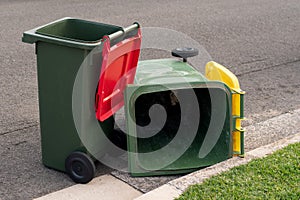 Australian garbage wheelie bins with colourful lids for general and recycling household waste on the street kerbside