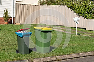 Australian garbage wheelie bins with colourful lids for general and recycling household waste on the street kerbside photo