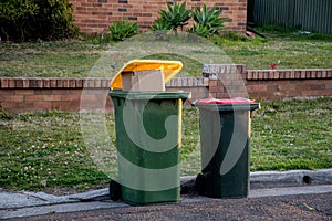 Australian garbage wheelie bins with colourful lids for general and recycling household waste on the street kerbside for council