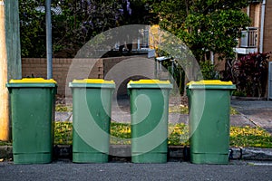 Australian garbage wheelie bins with colourful lids for recycling household waste on the street kerbside for council rubbish