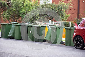 Australian garbage wheelie bins with colourful lids for recycling waste lined up on the street kerbside for council collection photo