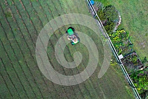 Australian man riding ride on lawn mower cutting green