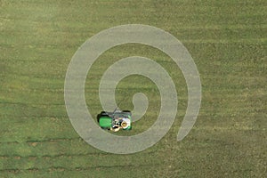Australian man riding ride on lawn mower cutting green